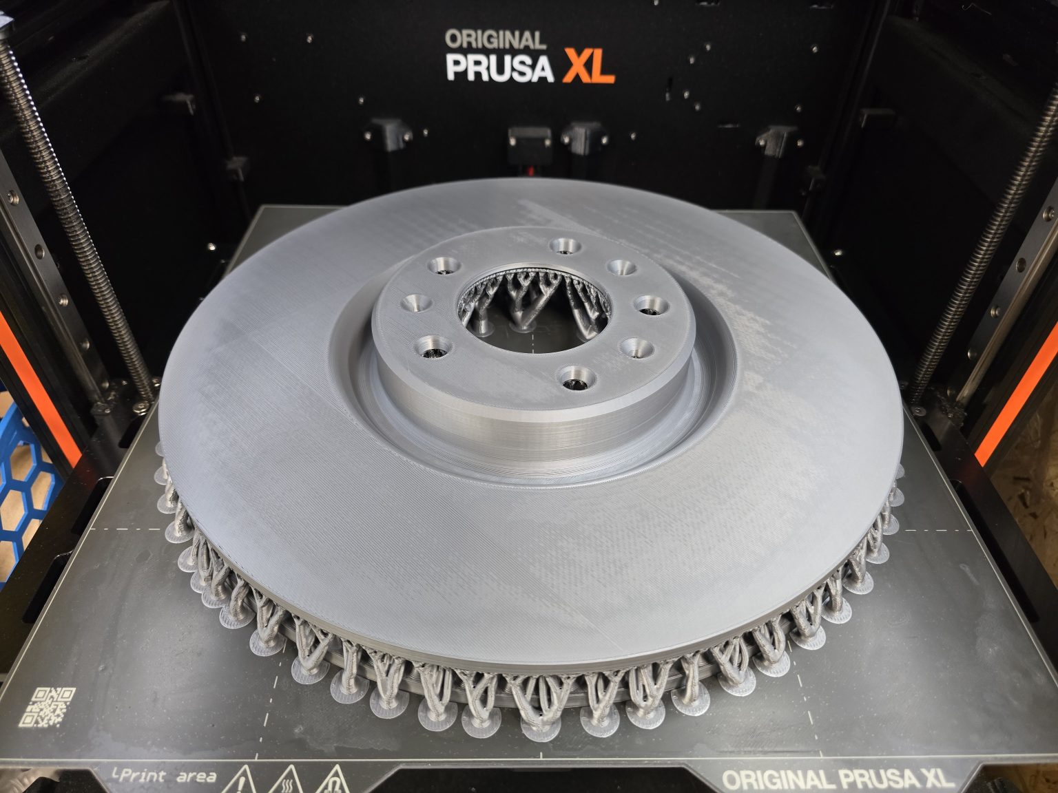 Geprinte remschijf met boomsupports op het printbed van een Prusa XL